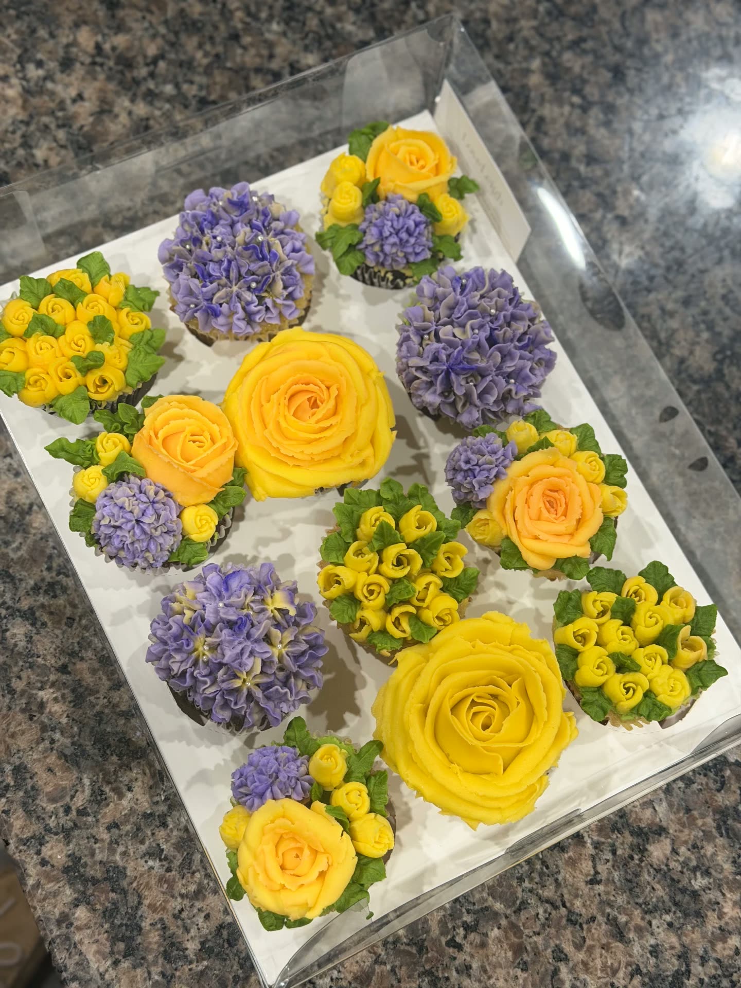 Yellow roses and lavender buttercream floral cupcakes in a gift box