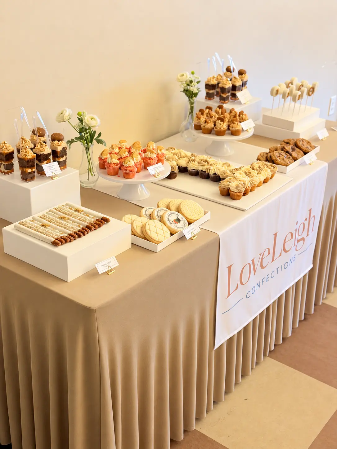LoveLeigh Confections branded dessert table with cupcakes, cookies, pretzels and dessert cups