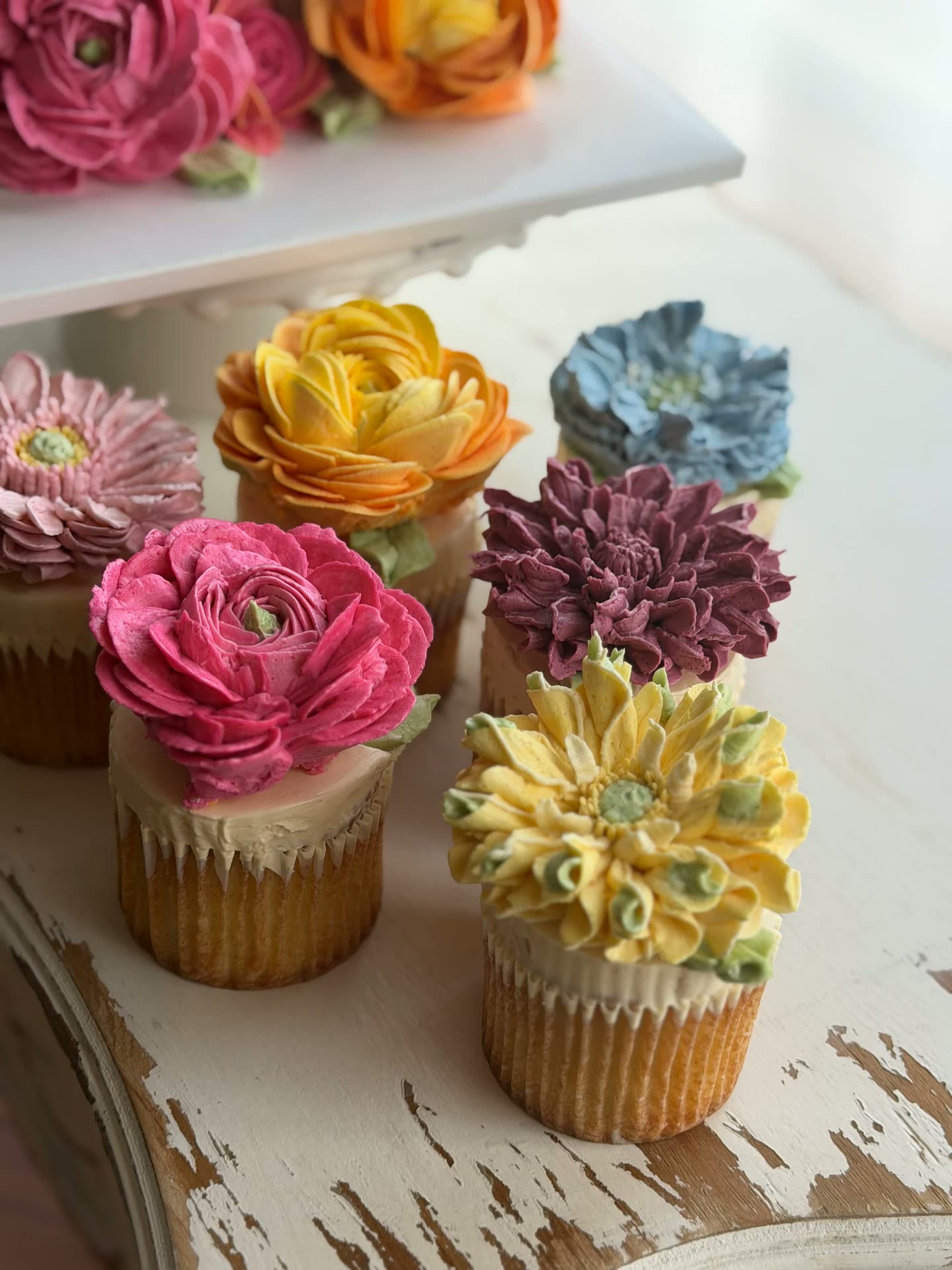 Buttercream flower cupcakes in pink, yellow, blue and plum