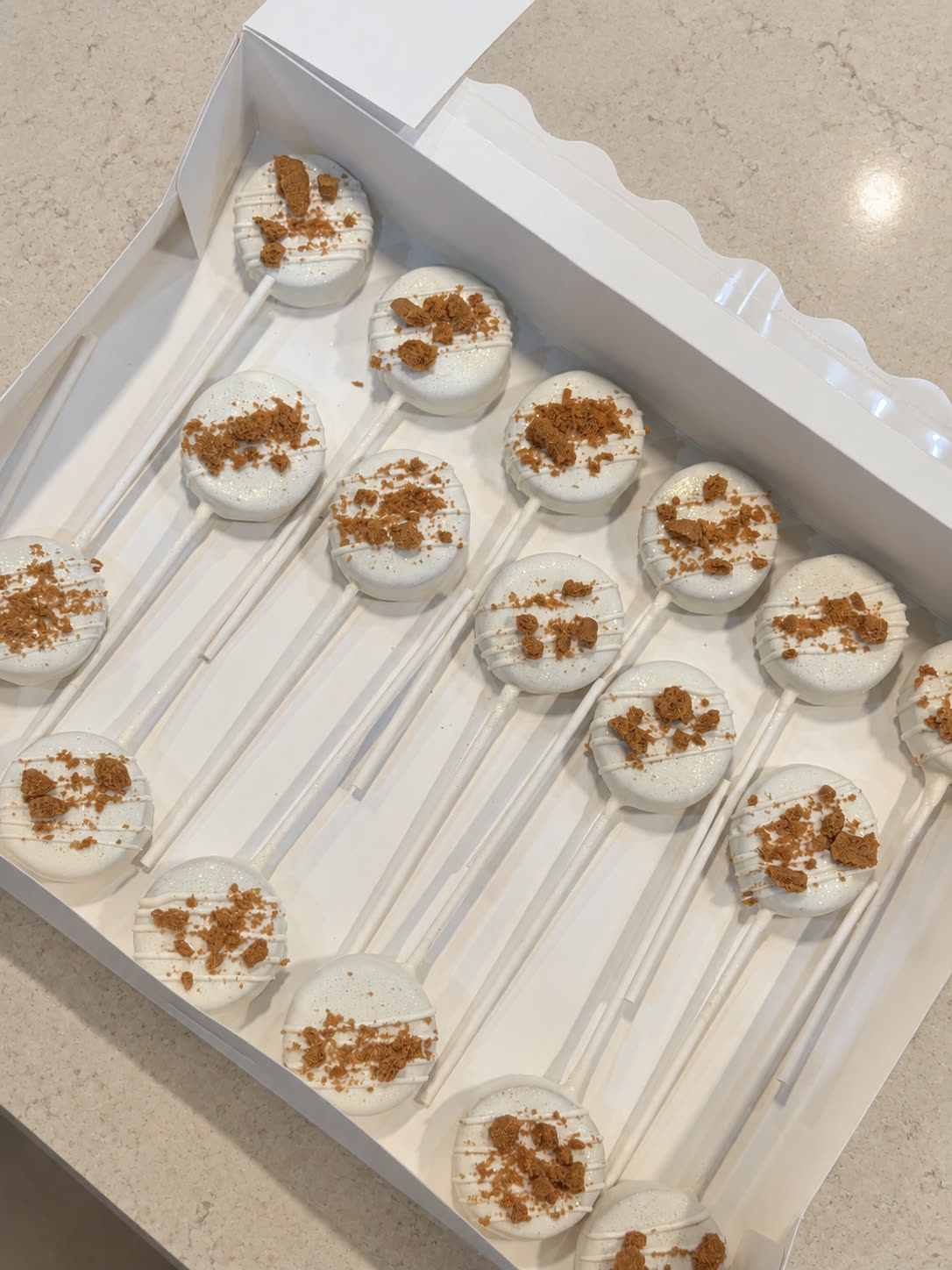White chocolate cake pops with cookie crumble in a bakery box