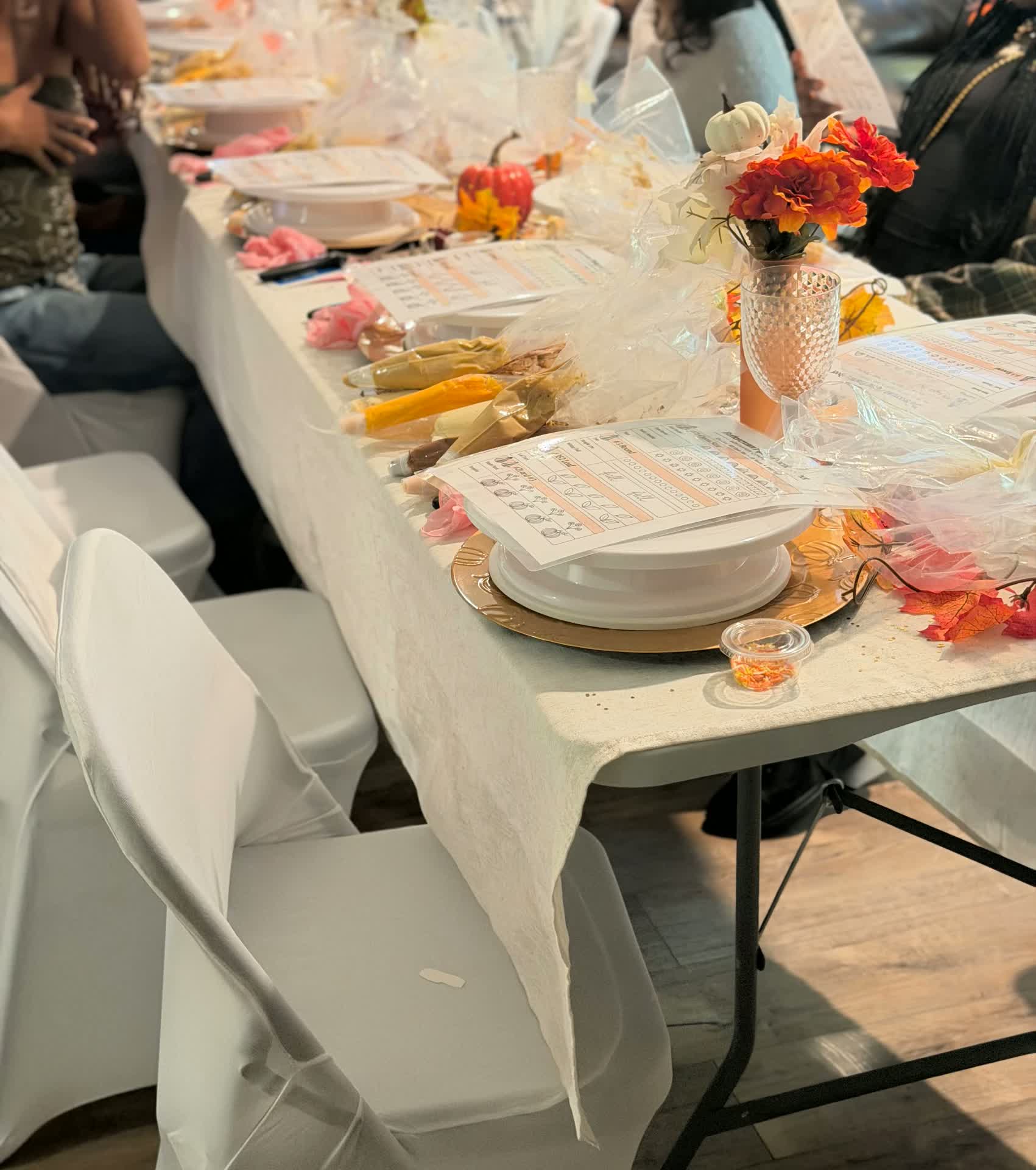 A guest place setting with a piping practice sheet, turntable and decorating tools