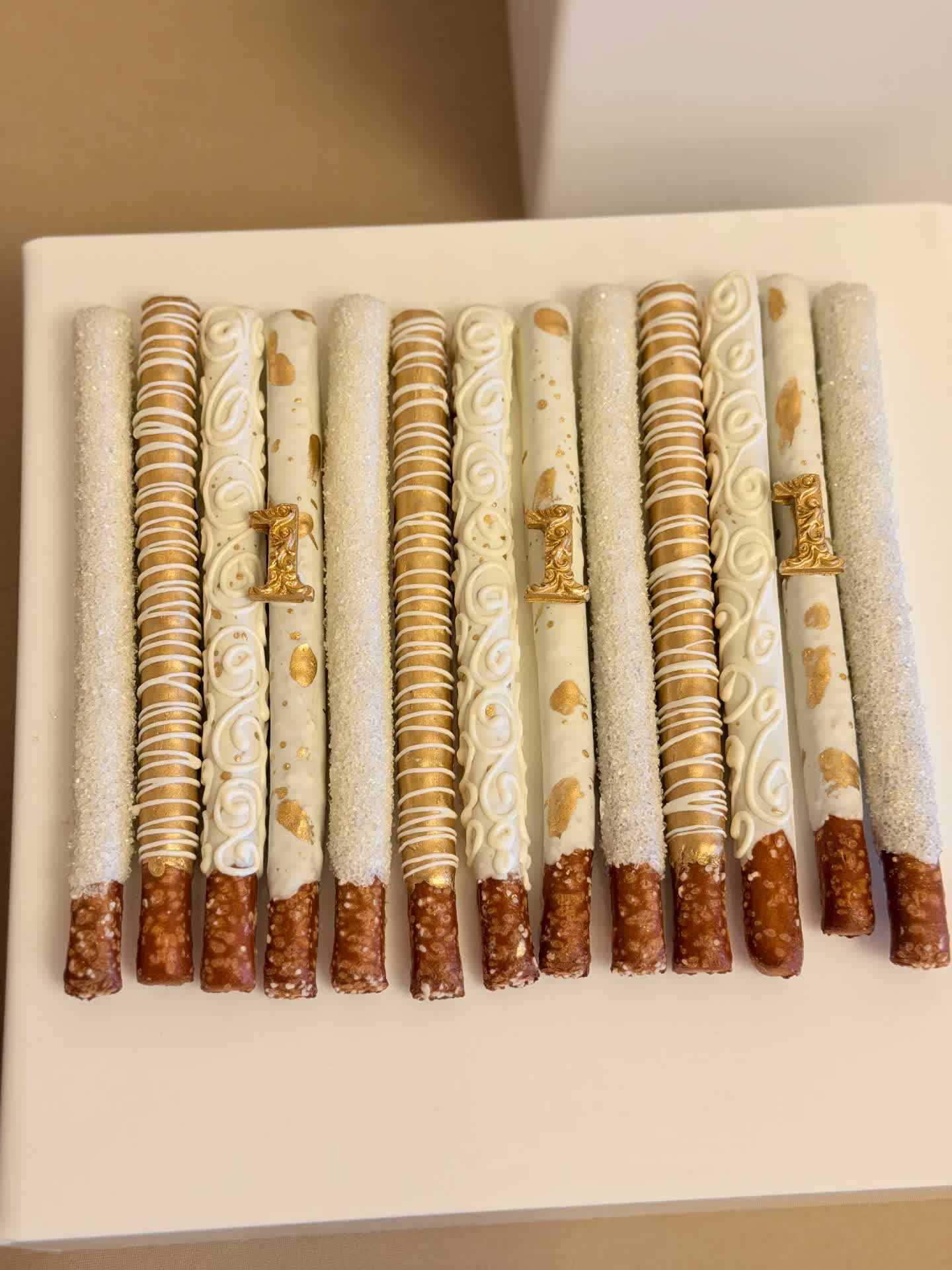 White chocolate and gold pretzel rods with gold number accents